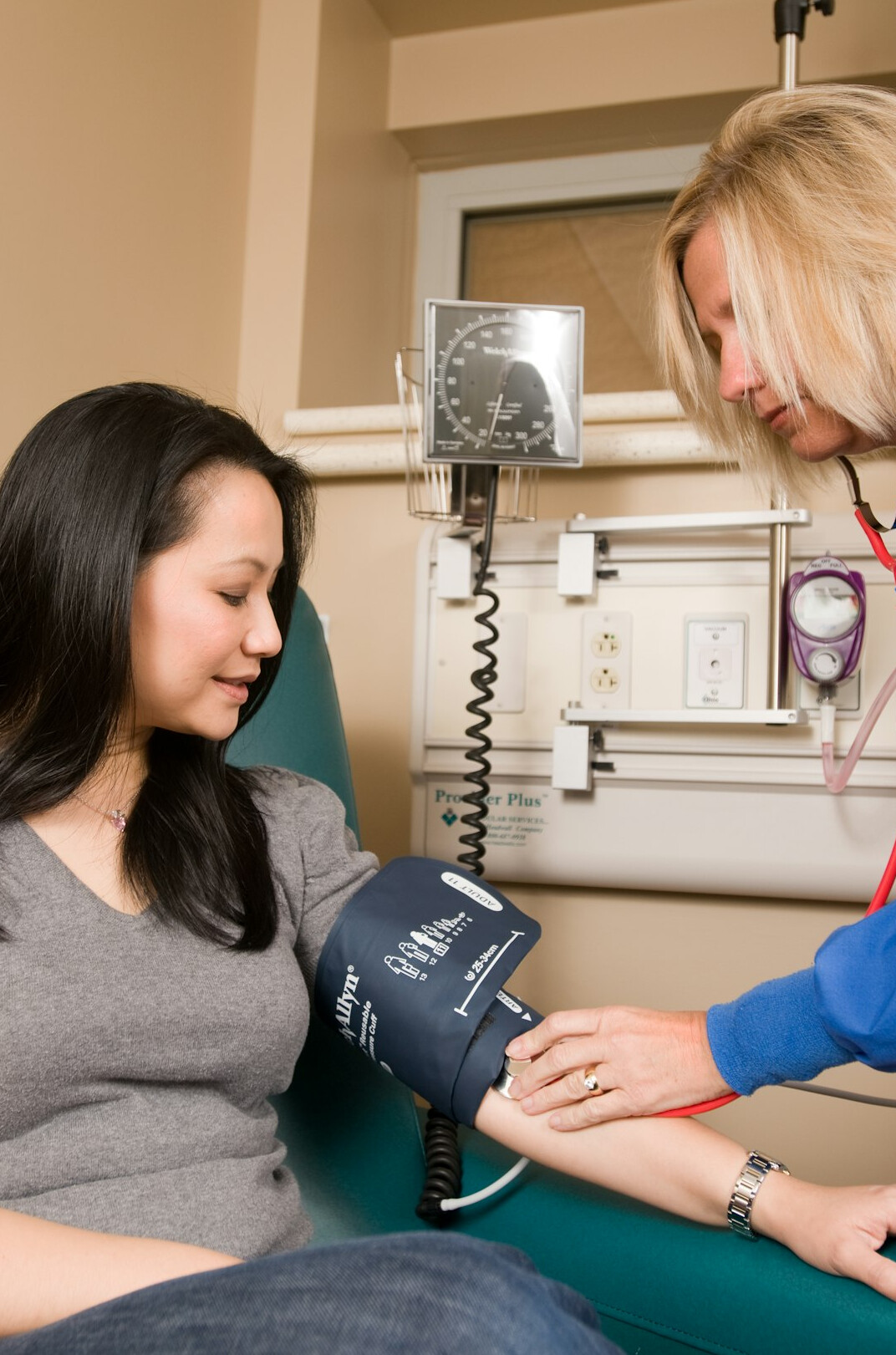 Health professional measuring blood pressure of an employee